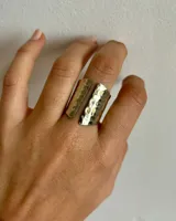 Anillo plateado de alpaca con diseño abierto y martillado.