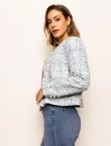 Chaqueta de tweed azul con cuello a la base, abertura central y bolsillos delanteros. Puños con aplique de botones perlados y forro interno.