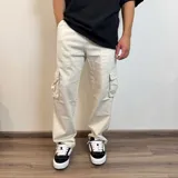 Pantalón jean color beige, corte recto y estilo cargo con bolsillos laterales.