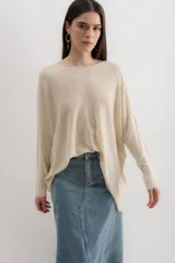 Sweater color crema de viscosa, poliéster, elastano y lurex, de corte holgado y mangas largas.