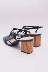 Sandalias de tacón color naranja, con puntera cuadrada, tiras finas con detalle de nudos y tacón geométrico de madera.