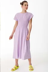 Vestido midi lila con cuello redondo y punto panal elastizado en la zona del busto. Tiene tajos laterales.