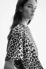 Remera oversized de punto de algodón con estampado de leopardo, cuello redondo ribeteado, hombros caídos y bajo recto.