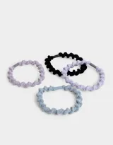 Set de cuatro gomitas de pelo elásticas con textura trenzada en colores celeste, beige, rosa y negro.