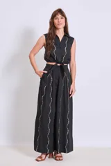 Camisa sin mangas color negro con cuello clásico, abotonada al frente y detalle de strass en el frente.