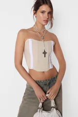 Corset strapless color beige con ballenas y elástico en la espalda. Presenta doble tira de ganchos lenceros en el delantero.