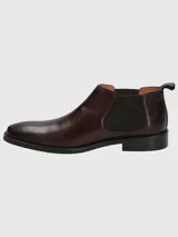 Bota Chelsea de cuero negro con elásticos laterales y suela plana.