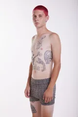 Short tipo boxer de tela elastizada con estampado geométrico en tonos beige y marrón.