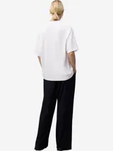 Camiseta blanca de algodón orgánico con corte relaxed fit, cuello redondo y manga corta. Presenta un bordado pequeño en el pecho.