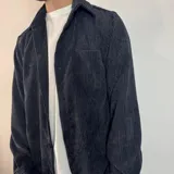Sobrecamisa color beige de pana con cuello clásico, cierre abotonado y bolsillo de parche en el pecho.