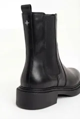 Bota tipo Chelsea de cuero negro con paneles elásticos laterales, tirador trasero y suela de goma con taco bajo.