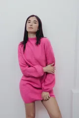 Vestido corto tejido de punto color fucsia, con cuello alto y mangas globo.