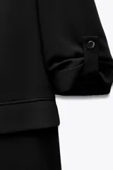 Blazer blanco con cuello solapa y hombreras. Manga por debajo del codo acabada en vuelta con trabilla y botón dorado. Bolsillos delanteros con solapa.
