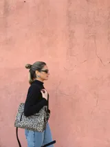 Cartera bandolera Shill Mini de cuero con estampado animal print, forro de tela y correa larga negra regulable. Cuenta con bolsillo frontal con cierre y bolsillo interno. Fabricación nacional.