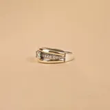 Anillo ancho de plata con textura brillante y banda central de oro. Segundo anillo de oro con hilera de circonias.