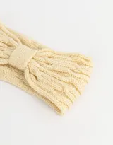 Vincha color beige de tejido de punto trenzado con detalle de lazo en el centro.
