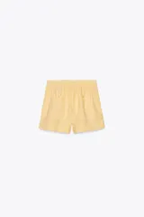 Shorts de tiro medio confeccionados en lino 100%. Cuentan con bolsillos laterales ocultos en la costura, bolsillos de parche en la parte trasera, cintura elástica, aberturas laterales en el bajo y cierre frontal con botones.