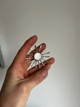 Collar con dije en forma de sol hecho a mano con centro de nácar redondo y rayos de plata. Incluye tiento de gamuza largo para usar doble o largo.