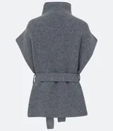Poncho de punto color gris con cuello alto y diseño de manga corta sin sisa. Incluye un cinturón del mismo material para ajustar a la cintura y presenta una textura acanelada.
