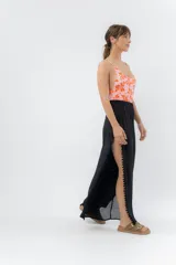 Pantalón blanco de gasa liviana con cintura elástica y aberturas laterales con detalle de pompones.