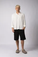 Camisa de manga larga color beige claro, con cuello abierto y calce relajado.