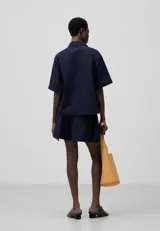 Bermuda corta azul marino de seersucker de algodón con volumen amplio, cintura elástica con cordón, bolsillos laterales y bolsillo de vivo en la espalda.