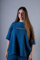 Remera de manga corta color azul con textura acanalada y bordado frontal con el nombre de la marca en color dorado.