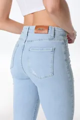 Pantalón jean negro de corte acampanado con aberturas en el ruedo.