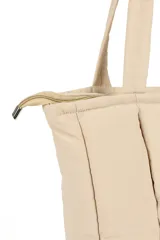 Bolso shopper color beige con diseño acolchado y pespuntes verticales. Tiene doble asa de hombro y cierre superior.
