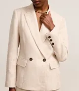 Blazer oversized color beige confeccionado en tweed. Posee cuello inglés, mangas largas, detalles de botones aplicados y solapas que imitan bolsillos.