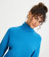 Blusa de punto color blanco, con cuello alto, manga larga y diseño liso.