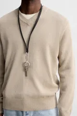 Jersey de punto color beige, con cuello en V y mangas largas.