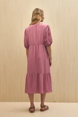 Vestido midi color marrón claro, con escote en V, mangas cortas abullonadas, botones frontales y falda con volantes.