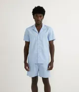 Pijama de dos piezas compuesto por camisa de manga corta con cuello solapa y abotonadura frontal, y bermuda con cintura elástica.