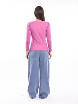 Remera de manga larga color fucsia con cuello redondo y detalle de pequeñas tachas plateadas alrededor del cuello.