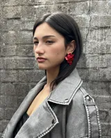 Campera de cuero sintético gris con cierre cruzado, cuello con solapas y cordones en los laterales.