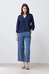 Blusa azul marino con textura de lunares, escote en V y mangas 3/4 abullonadas.