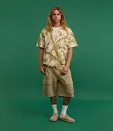 Remera de algodón color crudo con estampado de ramas y hojas en tonos marrones. Corte boxy, cuello redondo y mangas cortas.