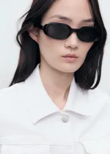 Chaqueta de jean blanca con cuello camisero, bolsillos de parche con solapa en el pecho, cierre frontal con botones y mangas largas con puños abotonados.