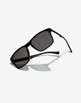 Lentes de sol Hawkers unisex con montura rectangular negra y lentes grises.