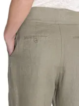 Pantalón de lino color verde, de tiro alto y pierna recta, con cierre cruzado y hebillas en los costados.