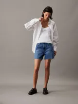 Shorts de jean de tiro alto, color azul medio, con bajo desflecado y diseño de cinco bolsillos.