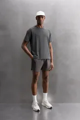 Camiseta deportiva verde militar confeccionada en tejido estructurado, ligero y elástico. Tiene cuello redondo, manga corta y bajo con aberturas laterales. Incluye logo estampado en el bajo.