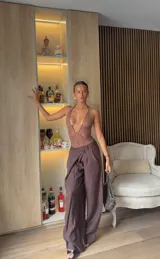 Body de encaje negro con escote en V profundo, tirantes halter con detalles metálicos y corte tipo tanga.