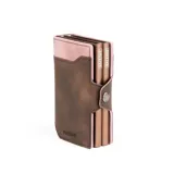 Billetera doble de cuero marrón con detalles en rosa. Cuenta con doble caja de aluminio con sistema de deslizamiento para tarjetas, clip para billetes y espacio adicional para documentos.
