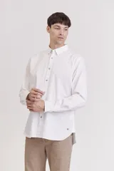 Camisa blanca de manga larga con cuello abotonado.