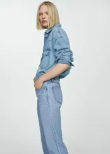 Pantalón de jean celeste de corte recto, tiro medio, con cinco bolsillos, trabillas y cierre de cremallera y botón.