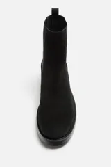 Bota Chelsea de cuero negro con elástico lateral, tirador trasero y suela con ligero tacón.