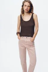 Pantalón de jean gris oscuro, de corte mom fit, tiro alto y largo tobillero. Cuenta con cinco bolsillos, cierre frontal con cremallera y botón.