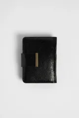 Billetera pequeña de cuero sintético negro con acabado metalizado y broche dorado.